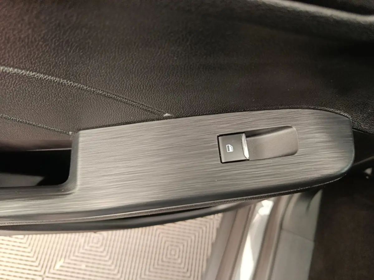 Gros plan sur la commande de lève-vitre côté gauche intérieur d'un Ford Kuga gris clair 2024 St Line.