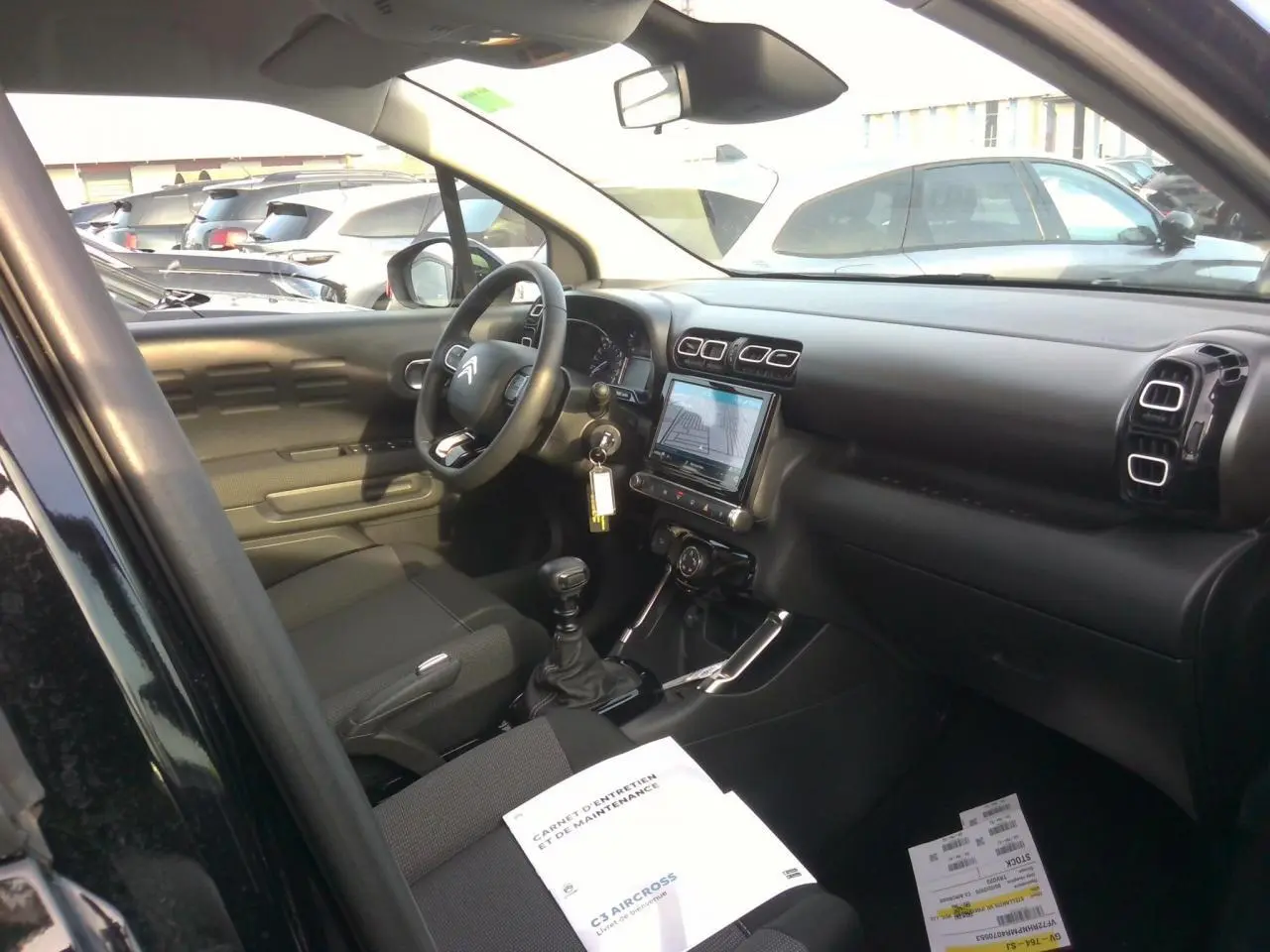 Intérieur noir du Citroën C3 Aircross 2024, vue côté conducteur avec tableau de bord et écran tactile central.