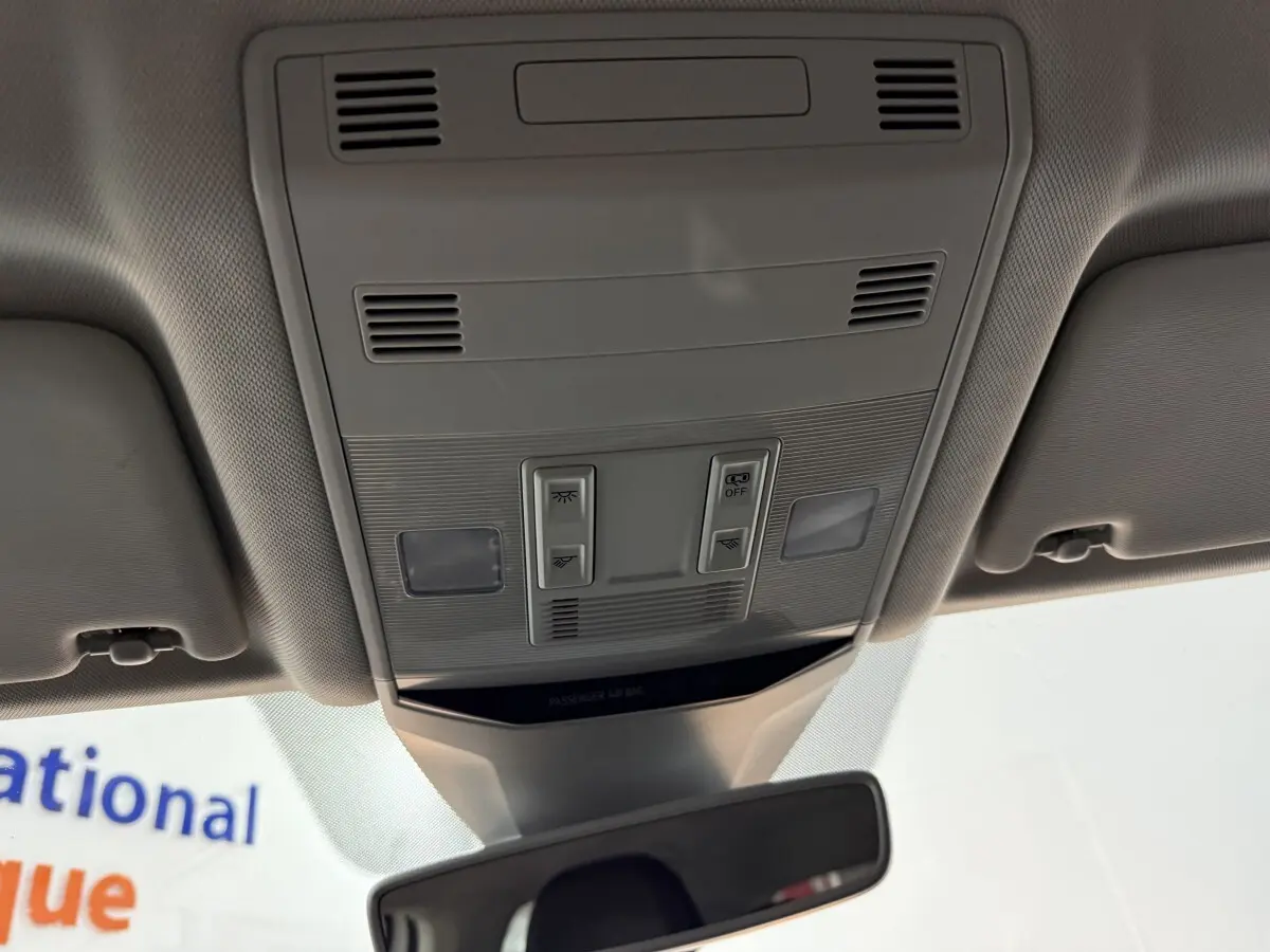 Vue intérieure du plafonnier gris avec commandes d'éclairage et rétroviseur dans un Volkswagen T-Roc blanc 2020.