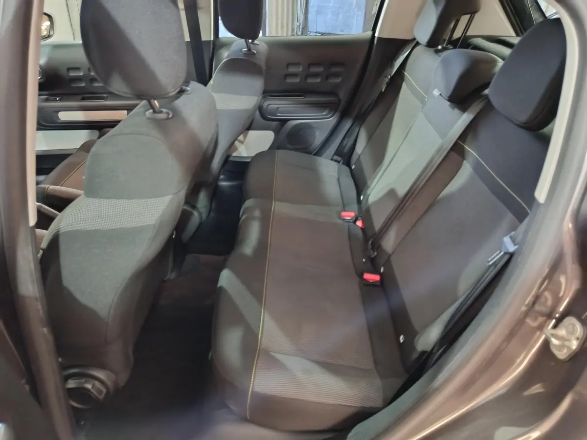 Vue intérieure côté droit sur la banquette arrière gris foncé de la Citroën C3 2024 avec ceintures et appuie-têtes.