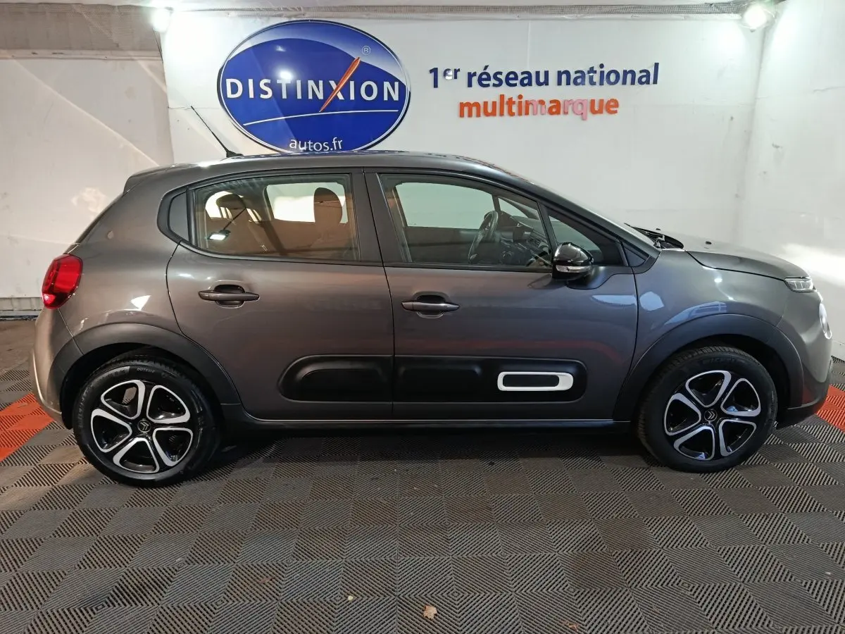 Profil droit d'une Citroën C3 2024 gris foncé avec protections latérales noires et jantes alliage distinctives.