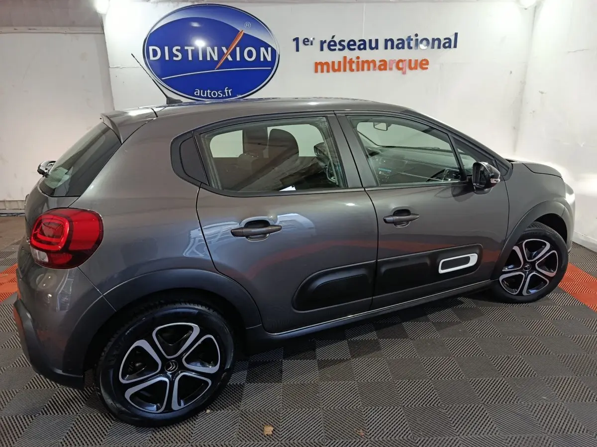 Vue latérale droite d'une Citroën C3 gris foncé 2024 avec protections latérales noires et jantes stylisées.