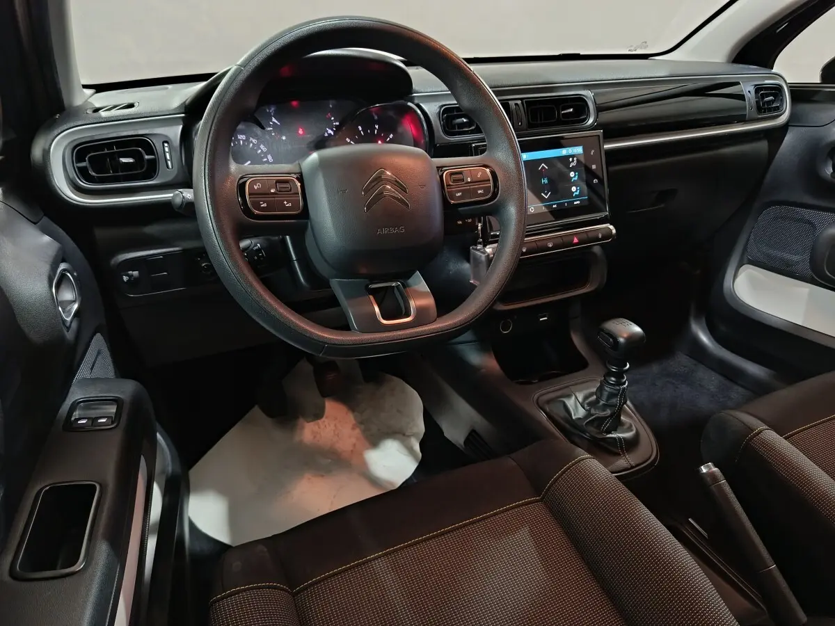 Vue intérieure avant de la Citroën C3 2024, volant multifonctions, tableau de bord tactile et levier de vitesse manuel.