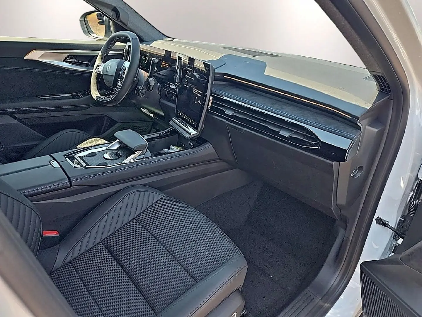 Vue intérieure côté passager du Renault Austral blanc nacré, avec sièges en tissu carbone et tableau de bord moderne noir.