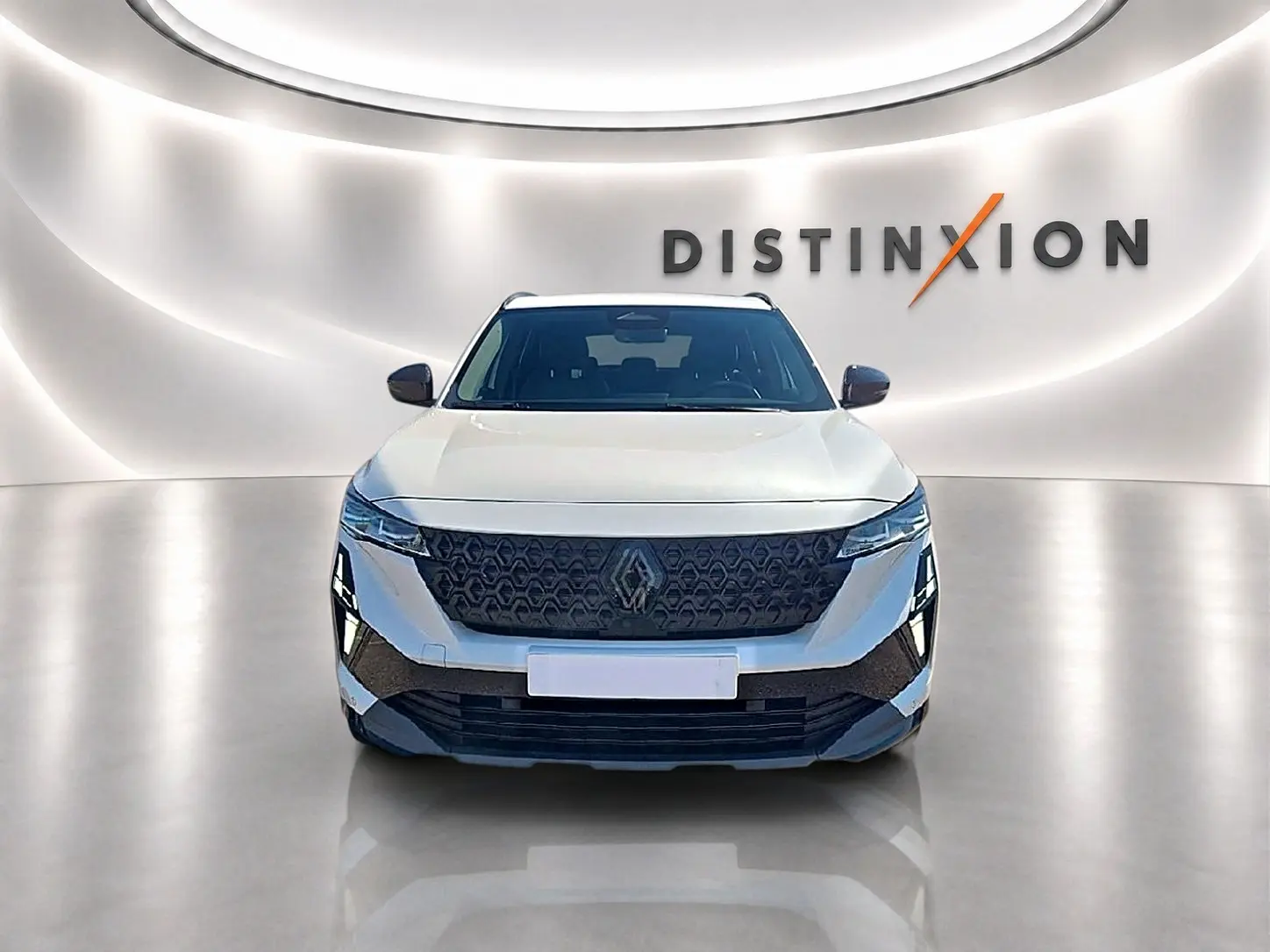 Vue avant d'un Renault Austral blanc nacré avec calandre noire et phares LED dans un showroom lumineux.