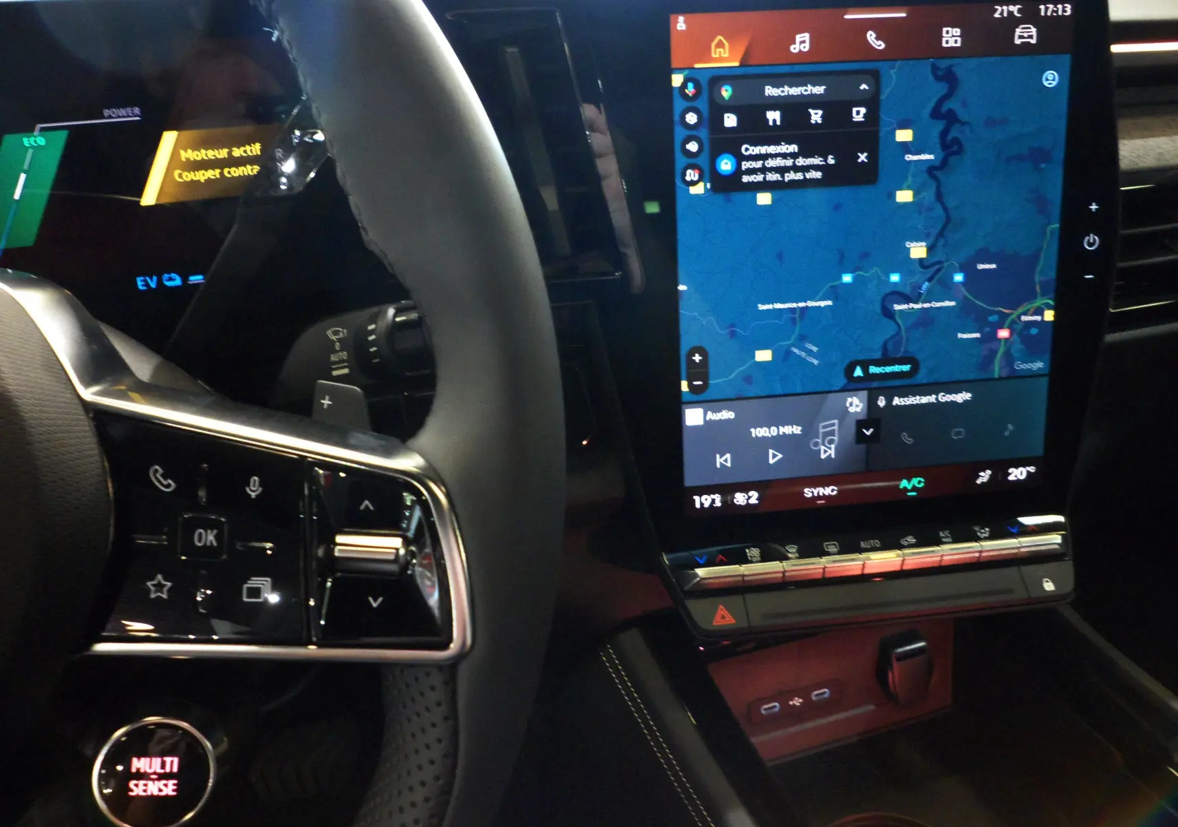 Vue rapprochée de l'intérieur du Renault Rafale E-Tech 2025, montrant le volant avec commandes et l'écran tactile central allumé.