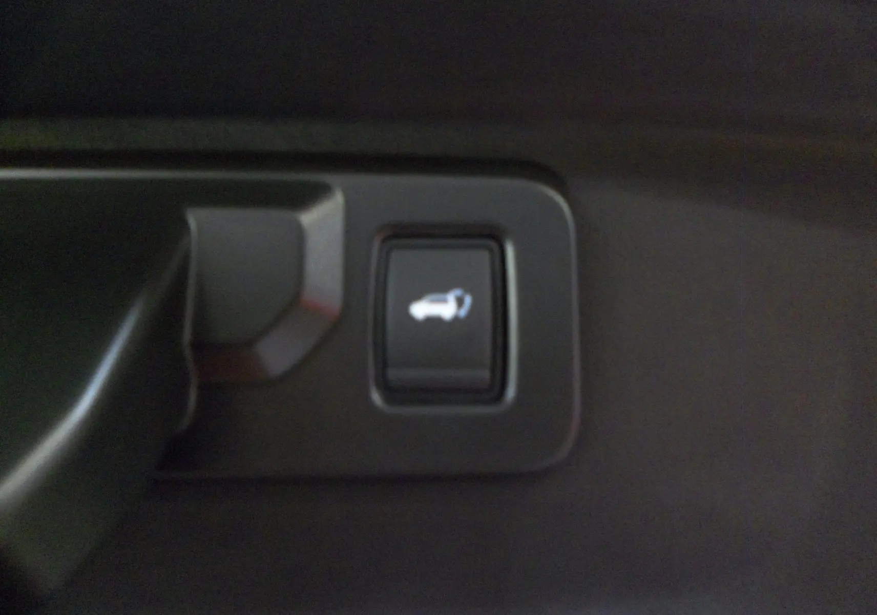 Bouton d'ouverture du coffre intérieur sur Renault Rafale E-Tech Full Hybrid 200 ch, finition rouge flamme toit noir.