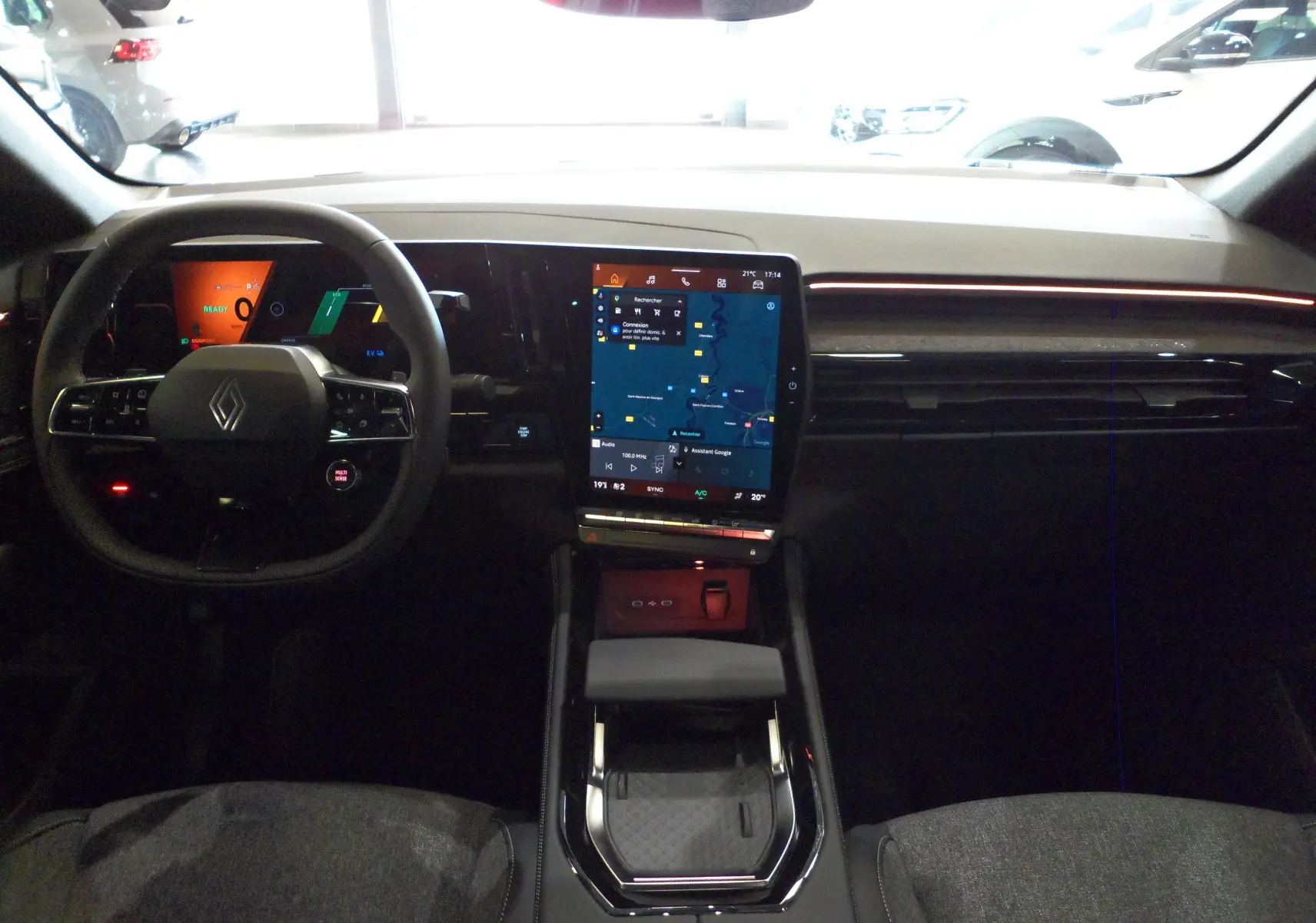 Vue intérieure avant du tableau de bord de la Renault Rafale E-Tech avec écran tactile central et volant multifonction.