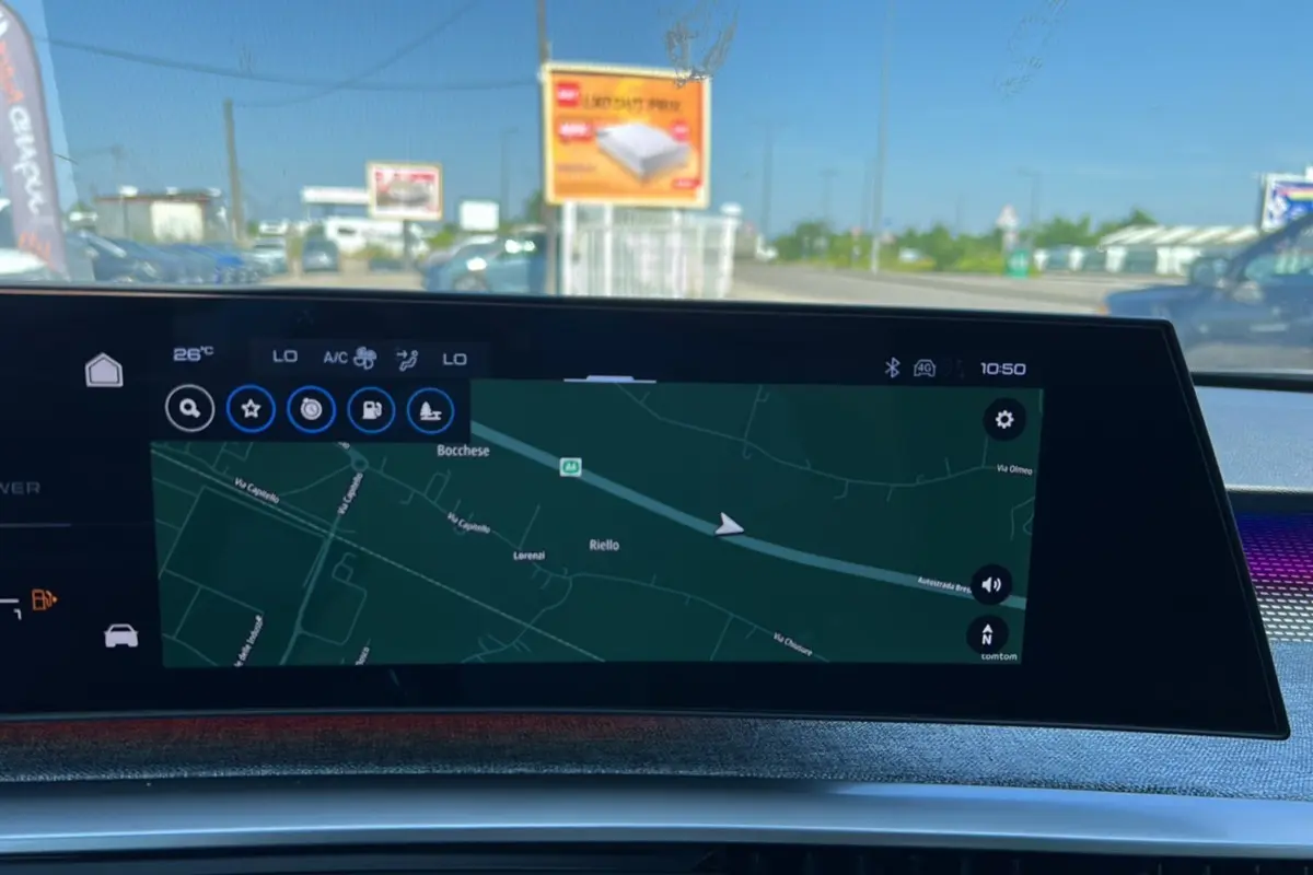 Écran tactile du tableau de bord du Peugeot 3008 Hybrid 2025 affichant la navigation GPS en extérieur lumineux.