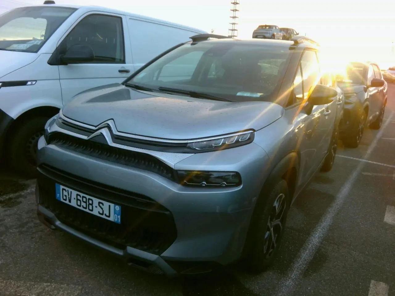 Citroën C3 Aircross gris foncé vue 3/4 avant droit avec jantes alliage et barres de toit noires.