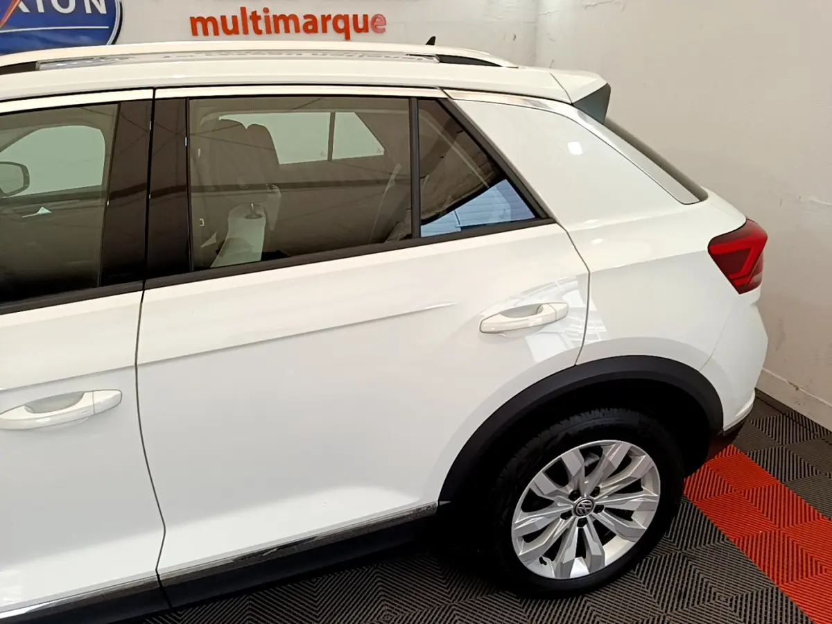 Vue latérale côté droit du Volkswagen T-Roc blanc 2020, mettant en valeur la porte arrière et la roue arrière en alliage.
