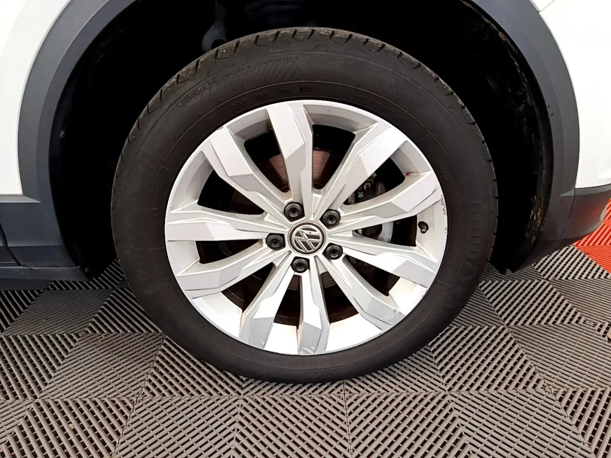 Gros plan sur la roue avant gauche blanche d'un Volkswagen T-Roc 2020 avec jante alliage à 10 branches.