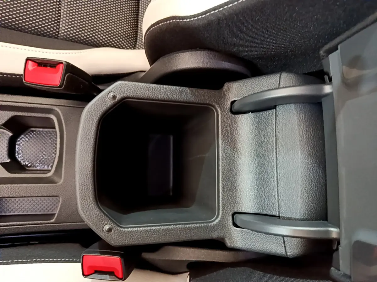 Gros plan sur le rangement central ouvert entre les sièges avant noir et blanc du Volkswagen T-Roc blanc 2020.