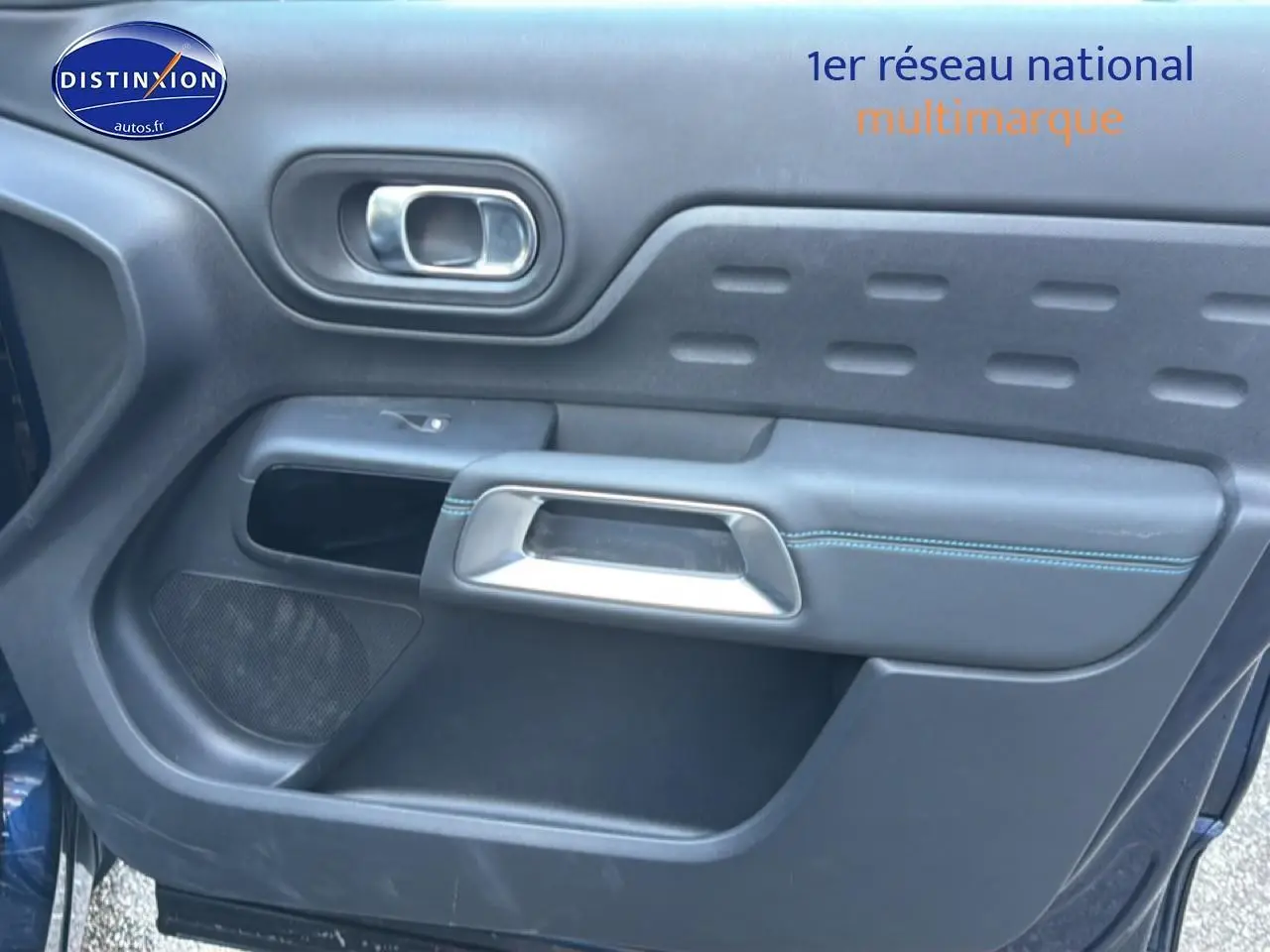 Vue rapprochée de la porte avant gauche du Citroën C5 Aircross bleu eclipse, avec poignée et haut-parleur intégrés.