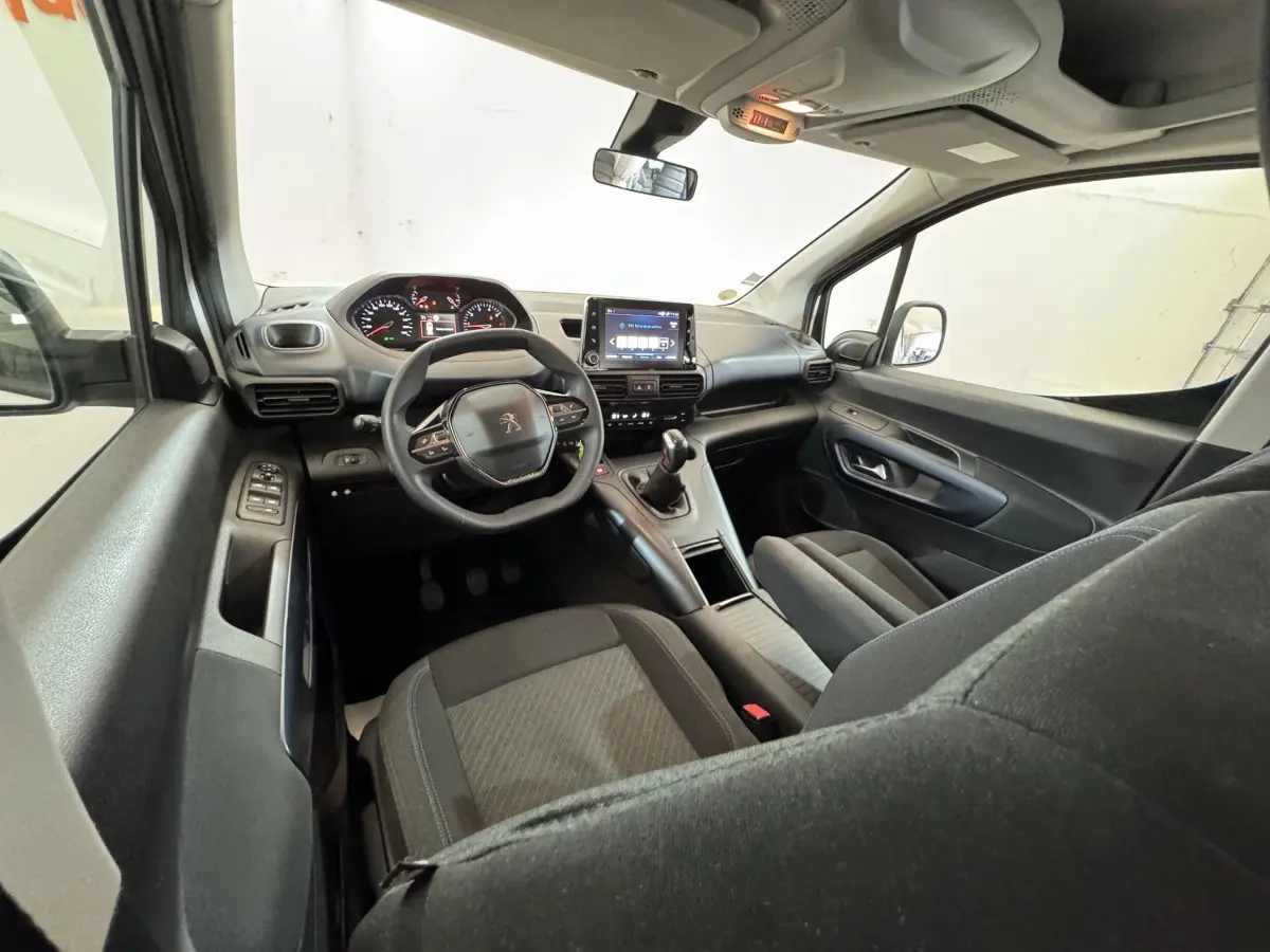 Vue intérieure côté conducteur du Peugeot Rifter 2019, tableau de bord avec écran tactile et volant multifonctions noir.