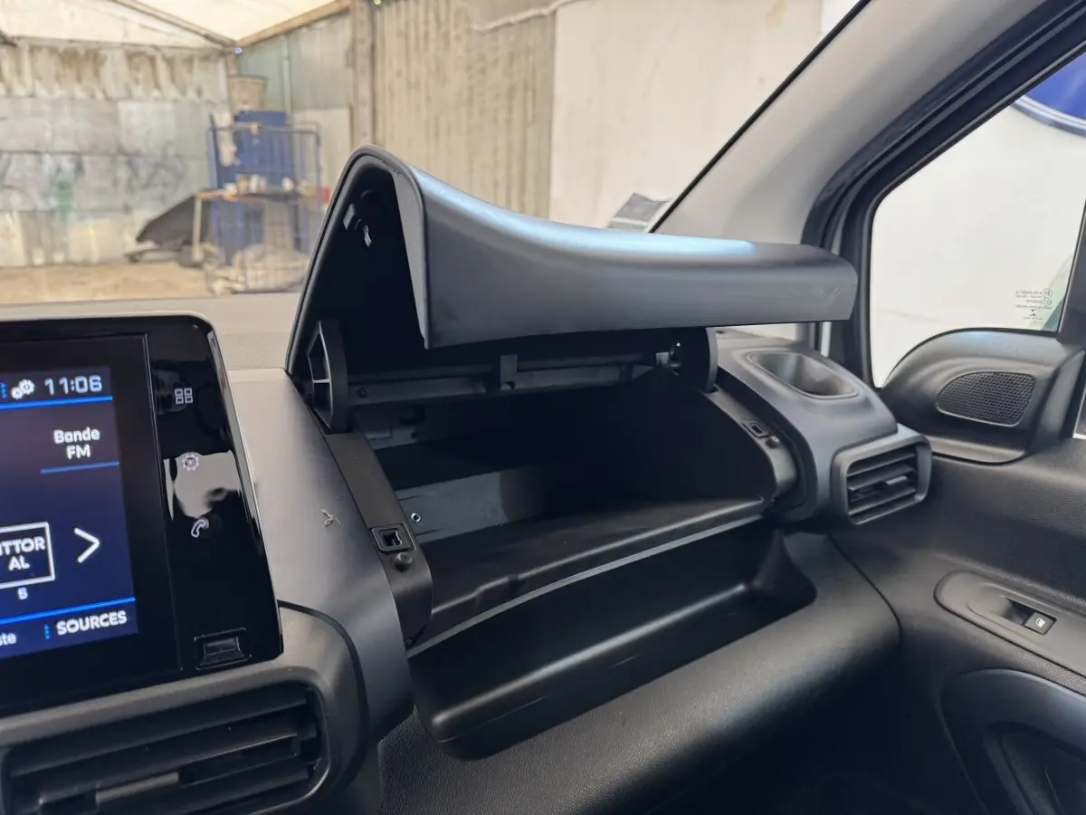 Intérieur du Peugeot Rifter blanc 2019, vue sur la boîte à gants ouverte côté passager et écran tactile du tableau de bord.