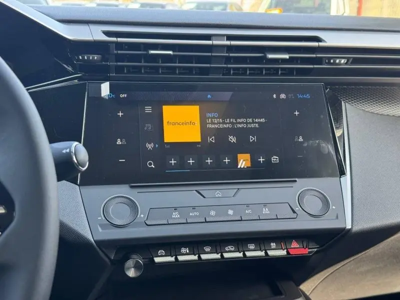 Vue rapprochée de la console centrale noire de la Peugeot 308 2025 avec écran tactile et commandes climatisation.