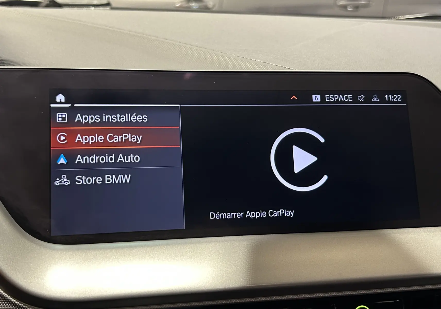Écran central tactile de BMW Série 1 16d 2023 affichant le menu Apple CarPlay en intérieur clair.