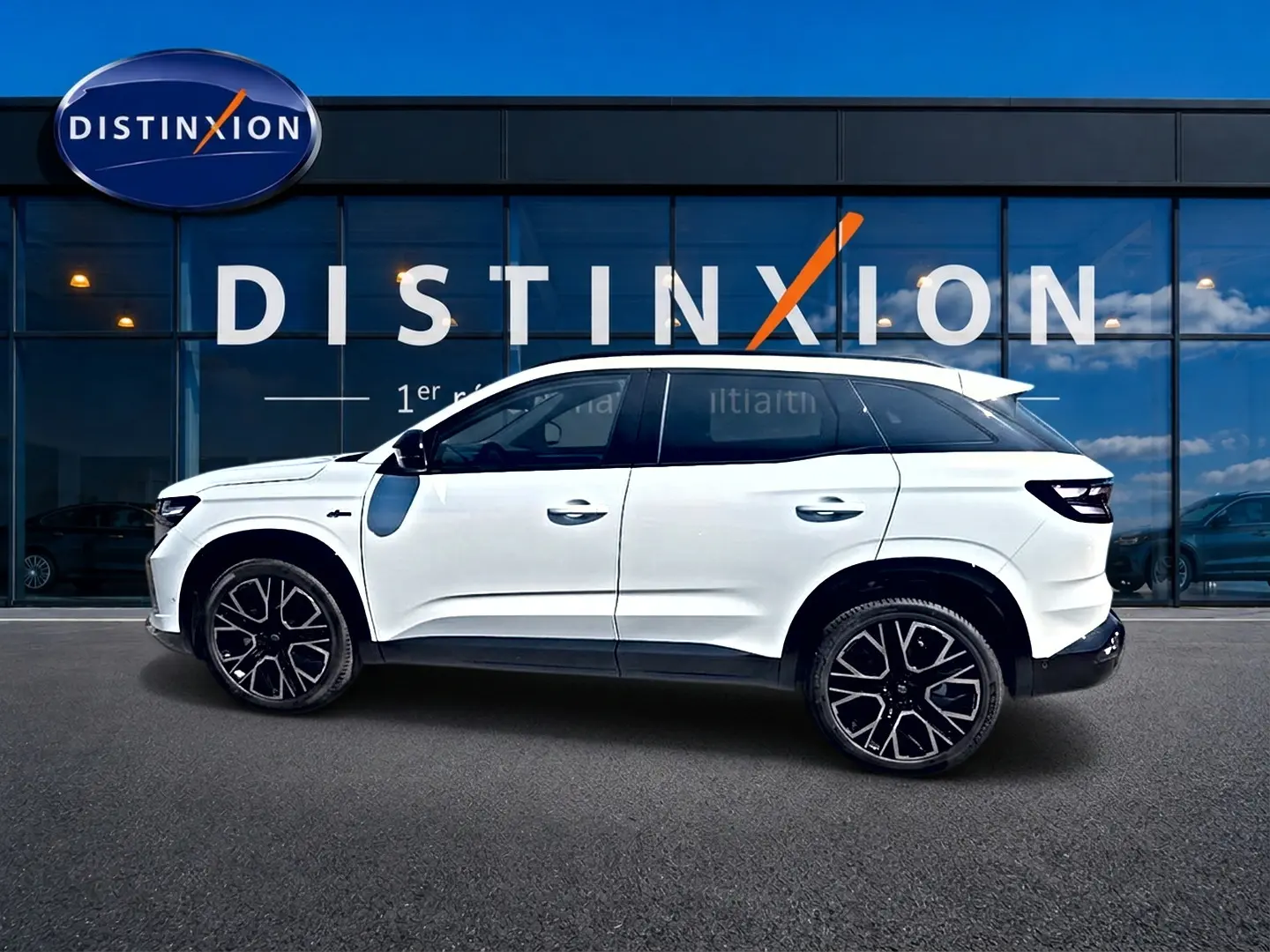 Profil droit du Renault Austral blanc nacré 2026 avec jantes alu noires et toit contrasté devant une vitrine Distinxion.
