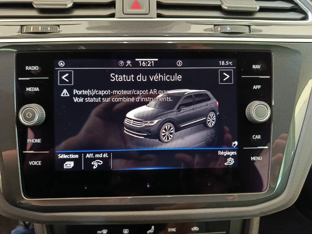 Écran tactile central affichant le statut du Volkswagen Tiguan 1.4 eHybrid 2022 en vue 3/4 arrière grise.