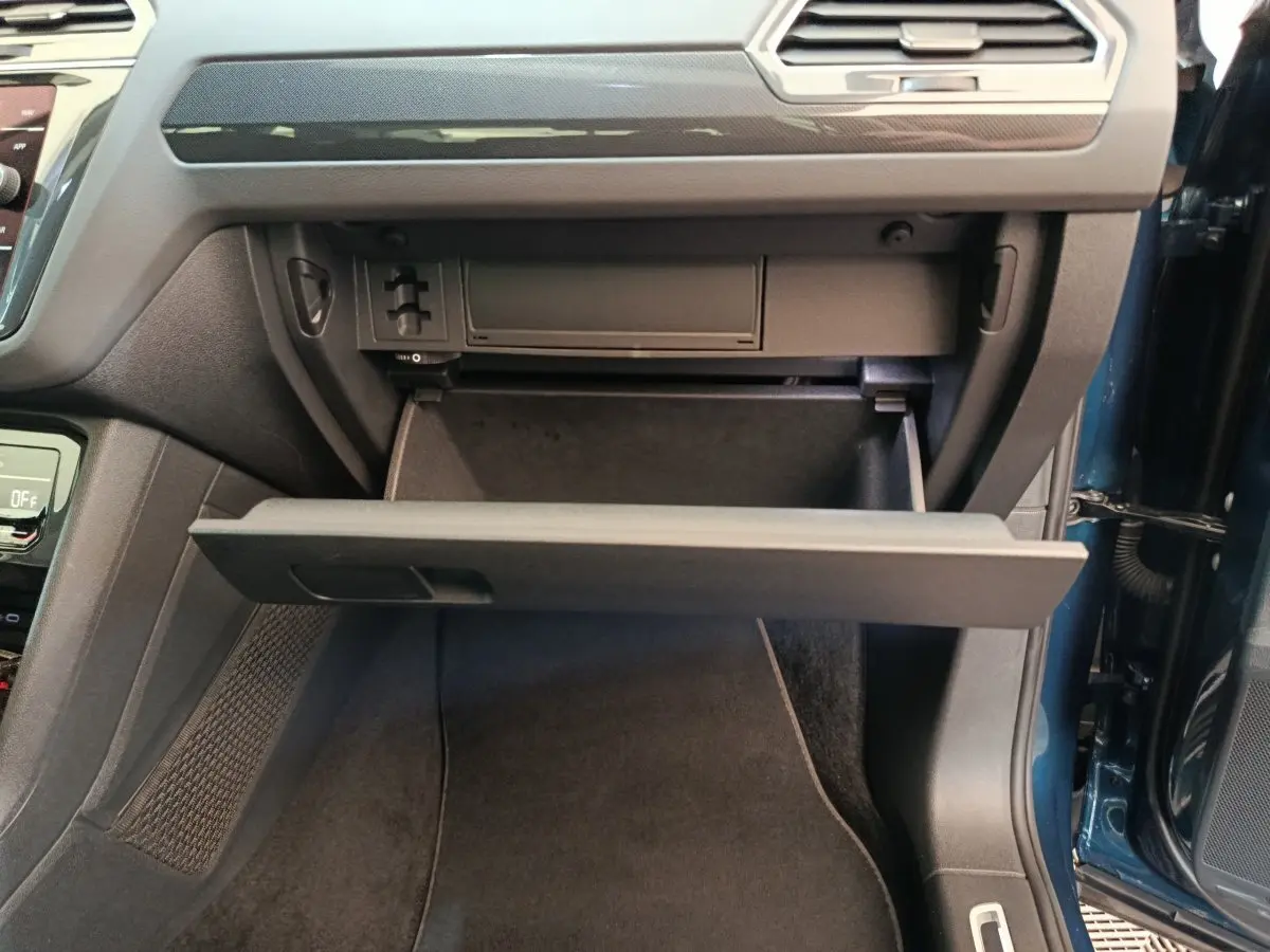 Gant de rangement ouvert côté passager dans l'habitacle du Volkswagen Tiguan bleu 2022 hybride rechargeable.