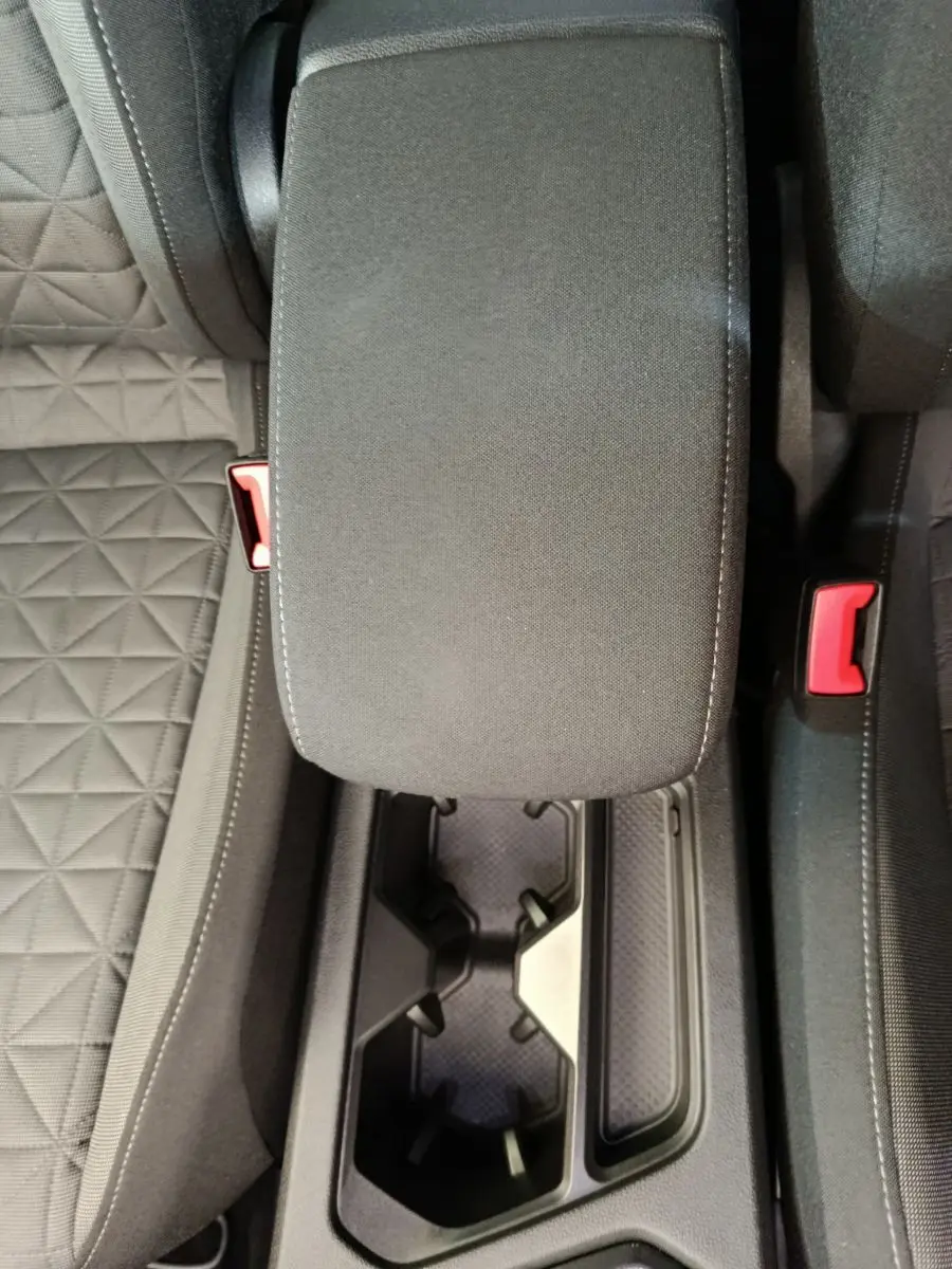 Gros plan sur la console centrale noire avec accoudoir et porte-gobelets du Volkswagen Tiguan hybride rechargeable 2022.