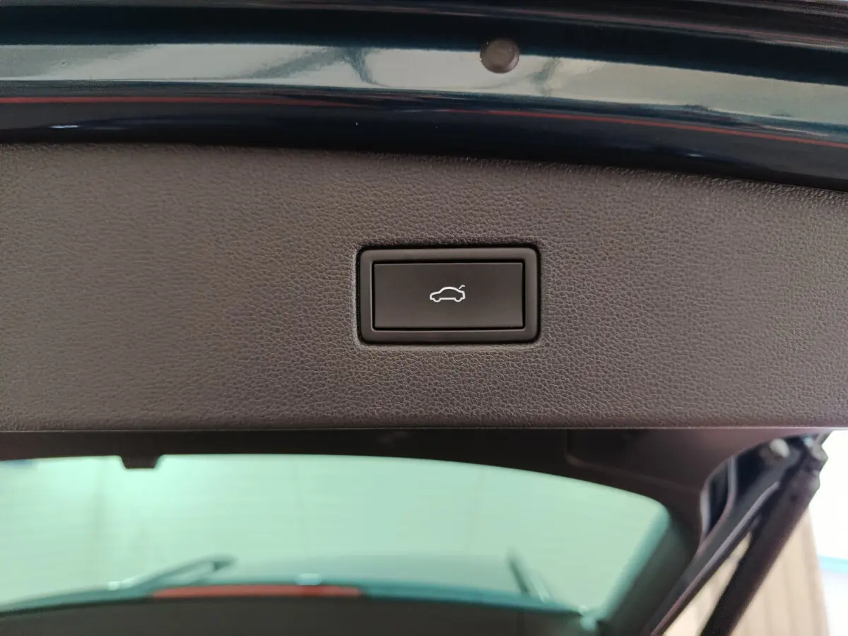Bouton d'ouverture électrique du coffre sur le hayon intérieur d'un Volkswagen Tiguan bleu 2022 hybride rechargeable.