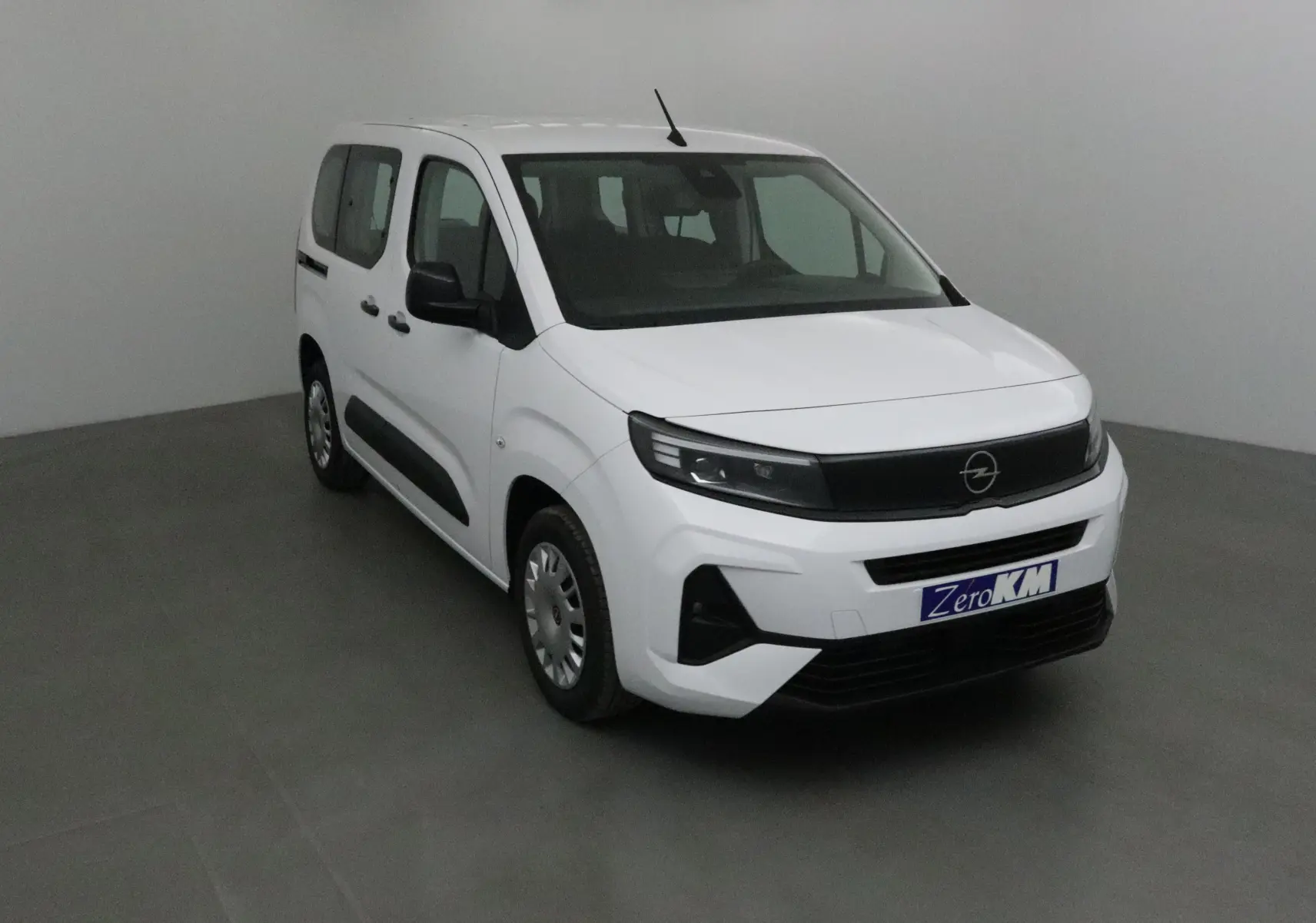 Opel Combo Life blanc en vue 3/4 avant droit, avec calandre noire et protections latérales noires visibles.