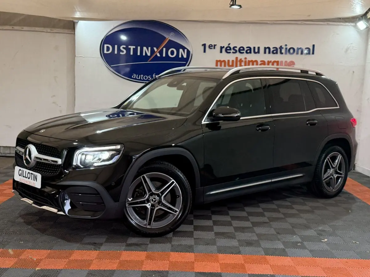 Mercedes GLB 200 d AMG Line noir vu de 3/4 avant droit, avec jantes AMG et barres de toit chromées visibles.