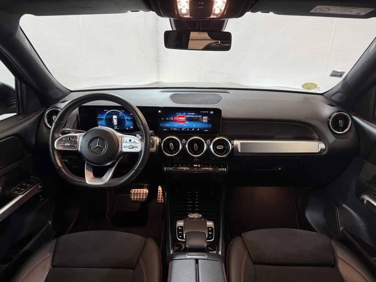 Intérieur noir du Mercedes GLB 200 d AMG Line 2020 vu de face, tableau de bord moderne avec écran tactile et volant multifonction.