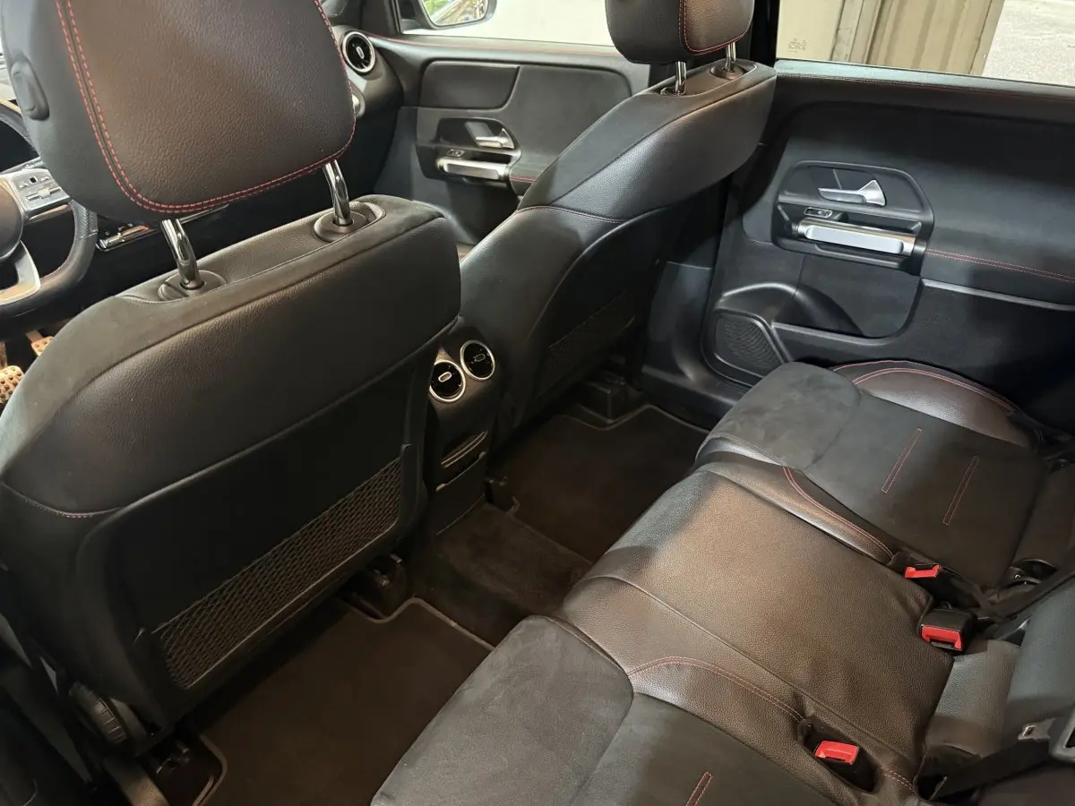 Vue intérieure arrière côté droit du Mercedes GLB 200 d AMG Line 2020 avec sièges en cuir noir et surpiqûres rouges.