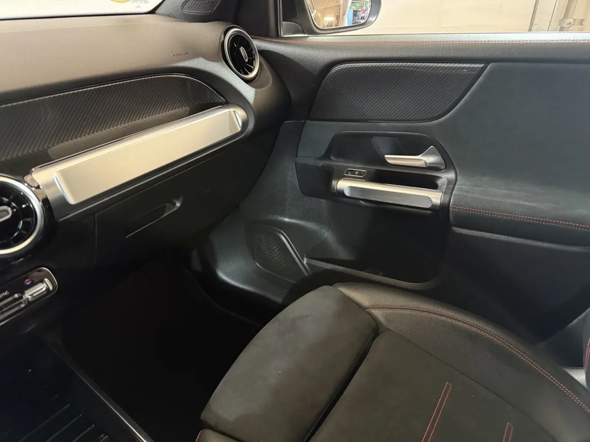 Intérieur côté passager du Mercedes GLB 200 d AMG Line noir, avec siège en alcantara et inserts aluminium sur la porte.
