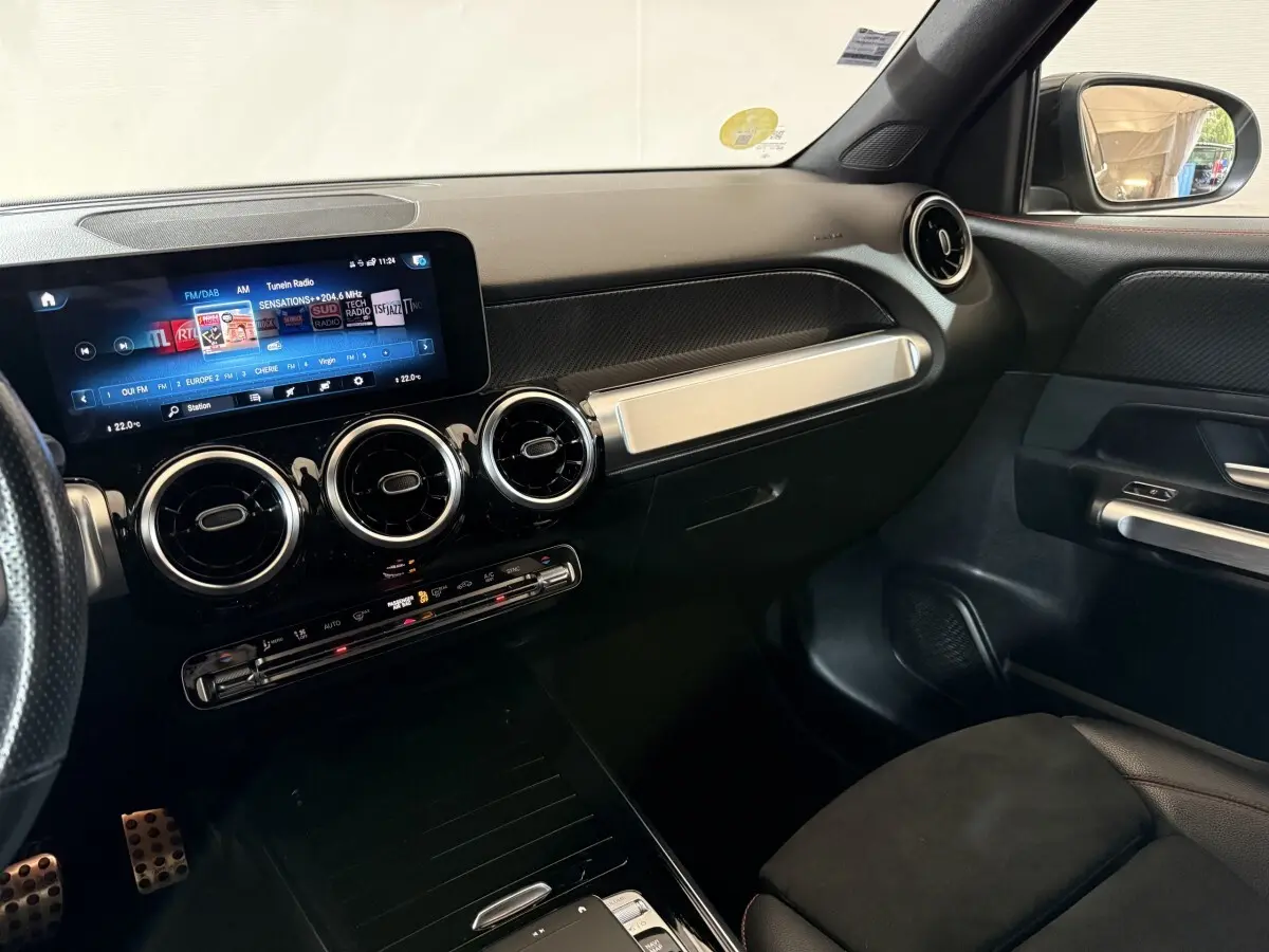 Intérieur du Mercedes GLB 200 d AMG Line 2020, vue du tableau de bord côté passager avec écran tactile et aérateurs ronds chromés.