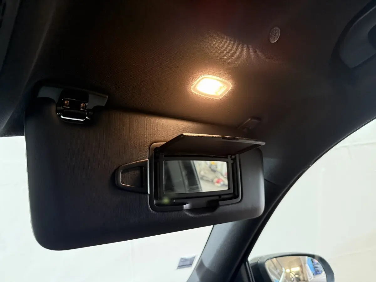 Miroir de courtoisie ouvert sur pare-soleil côté gauche dans l’habitacle noir du Mercedes GLB 200 d AMG Line 2020.