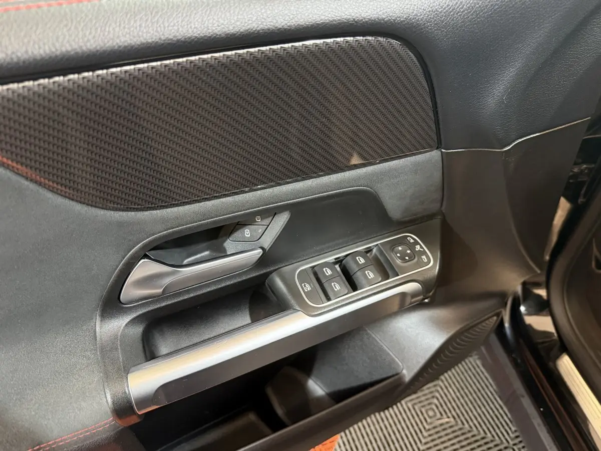 Détail de la porte avant gauche noire du Mercedes GLB 200 d AMG Line 2020 avec commandes des vitres et verrouillage.