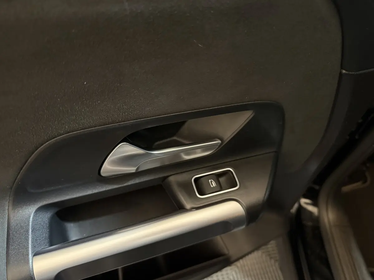 Poignée intérieure côté gauche avec commande de verrouillage sur porte noire d'un Mercedes GLB 200 d AMG Line 2020.
