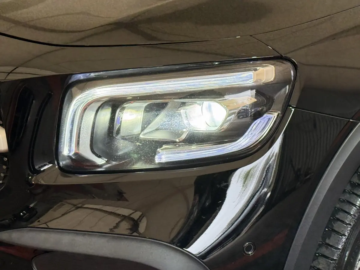 Gros plan sur le phare avant droit LED du Mercedes GLB 200 d AMG Line noir, soulignant ses lignes modernes et précises.