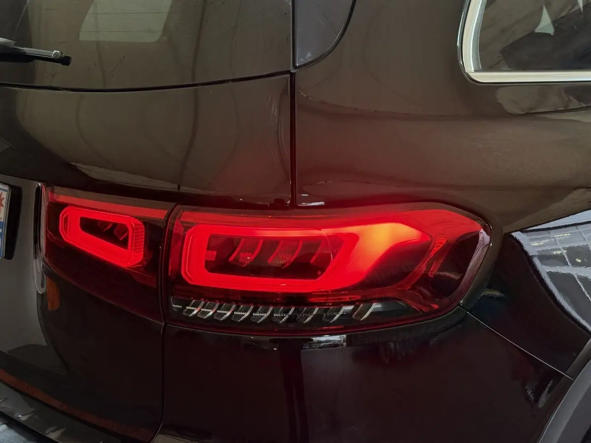 Gros plan sur le feu arrière droit rouge d’un Mercedes GLB 200 d AMG Line noir 2020, finition brillante.