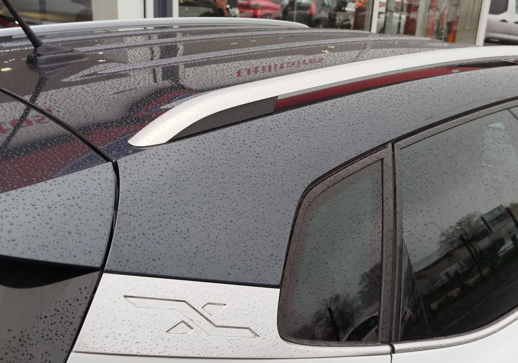 Détail du toit gris magnétique et de la partie arrière blanche du SEAT Arona 2020, vue côté gauche sous la pluie.
