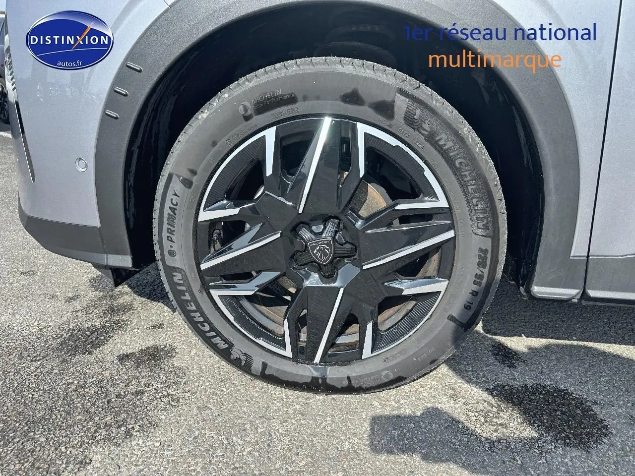 Gros plan sur la roue avant droite d’un Peugeot 3008 gris Artense avec jante alu noire et argentée.