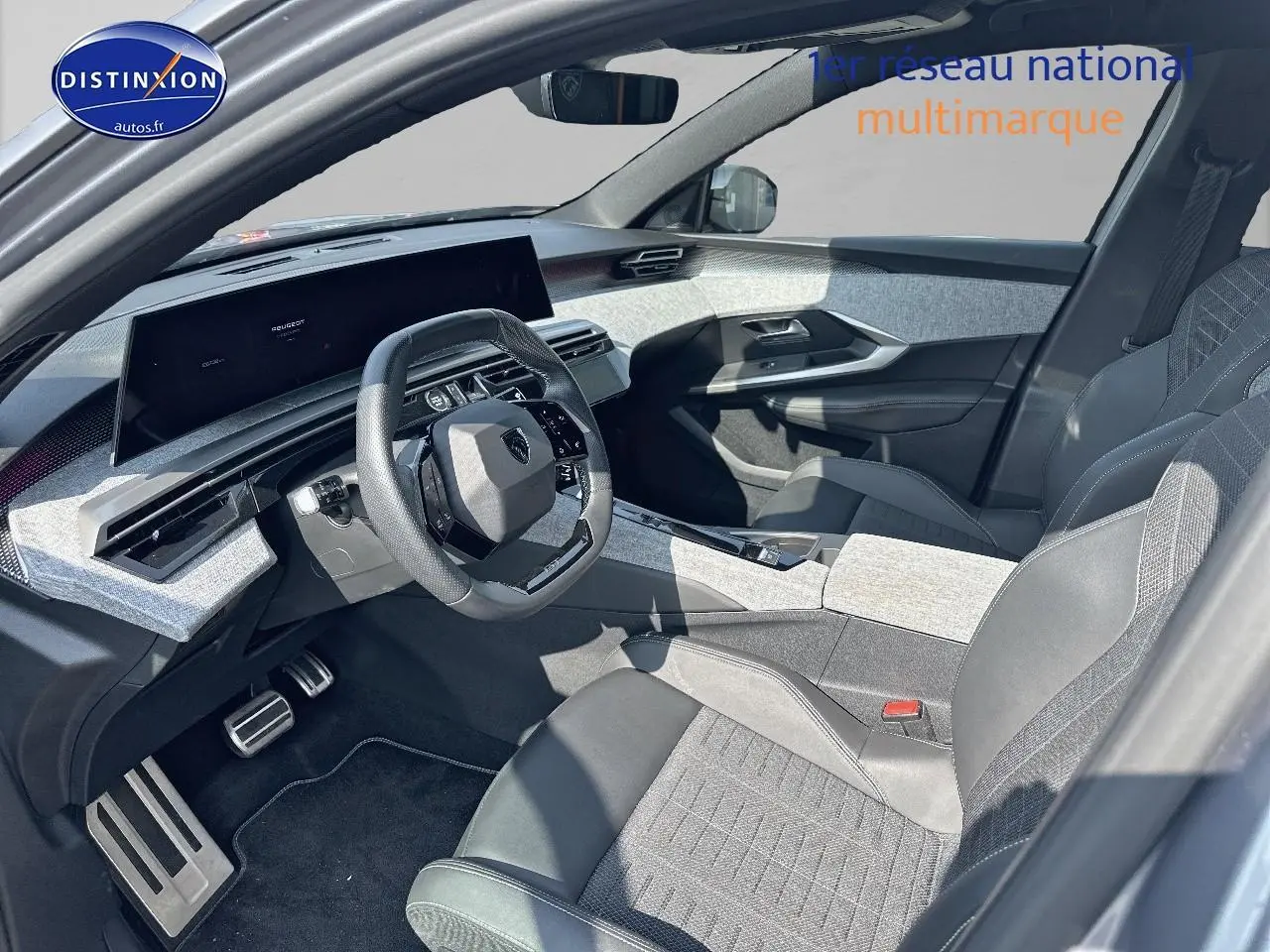 Vue intérieure côté conducteur du Peugeot 3008 gris artense, avec volant cuir multifonction et sièges bi-matière.