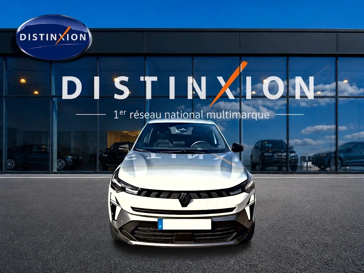 Vue frontale d'un Renault Symbioz blanc nacré garé devant une vitrine avec logo Distinxion.