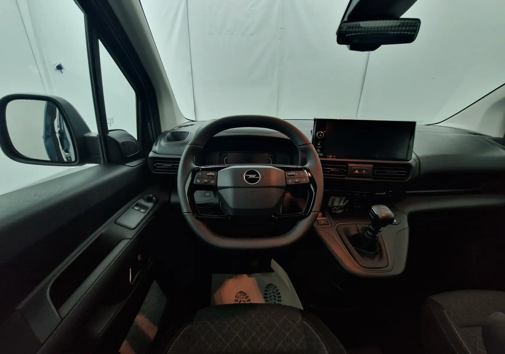 Intérieur de l'Opel Combo Life bleu Kiama, vue frontale du poste de conduite avec volant multifonction et boîte manuelle.