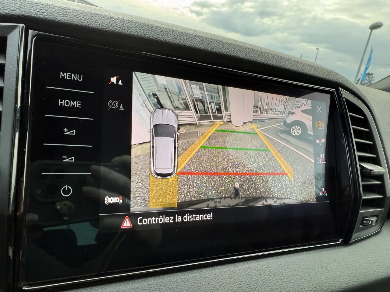 Écran multimédia du Skoda Karoq noir Magic nacré montrant la caméra de recul avec guidage de trajectoire coloré.