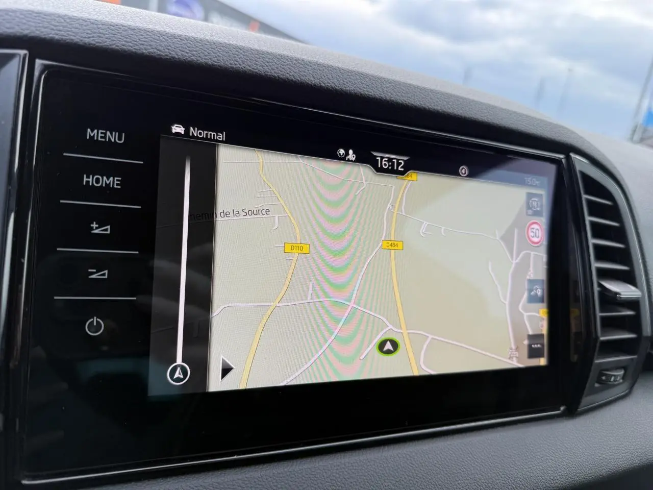 Écran tactile du système de navigation du Skoda Karoq 2.0 TDI Sportline avec interface claire et boutons tactiles noirs.
