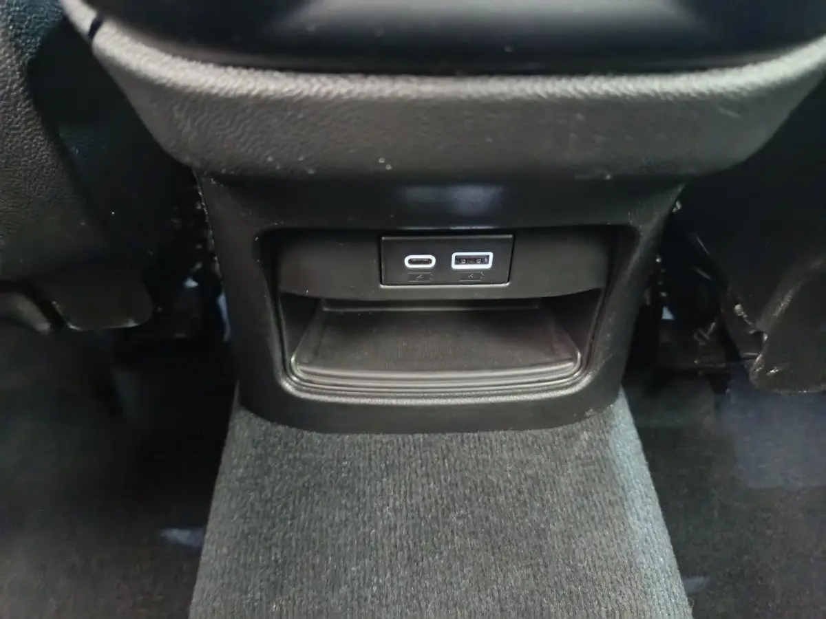 Prise USB type C et USB standard en bas de la console centrale noire de l'Alfa Romeo Stelvio Sprint 2024.