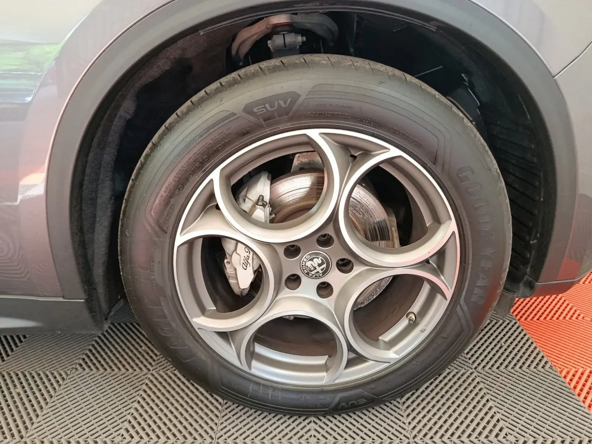 Gros plan sur la roue avant gauche grise d'un Alfa Romeo Stelvio 2.2 TD 160 AT8 Sprint avec jante en alliage distinctive.
