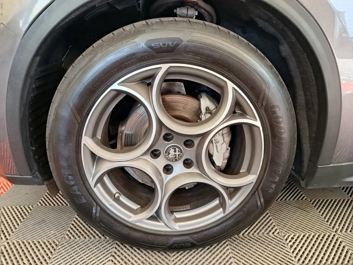 Gros plan sur la roue avant droite gris foncé d'un Alfa Romeo Stelvio 2.2 TD 160 AT8 Sprint avec jante en alliage distinctive.