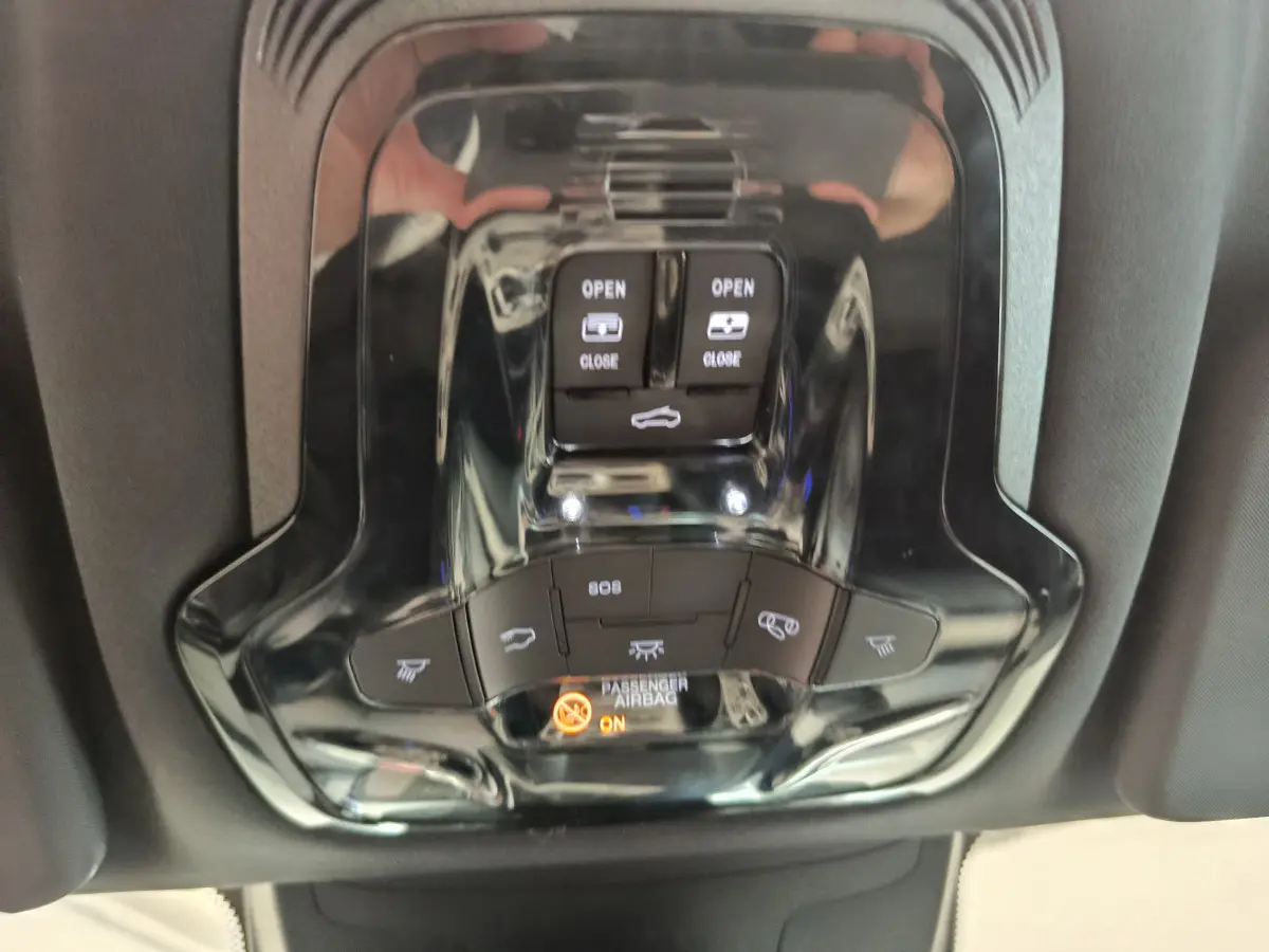 Vue rapprochée du panneau de commandes de toit ouvrant et éclairage intérieur noir brillant dans un Alfa Romeo Stelvio gris foncé 2024.