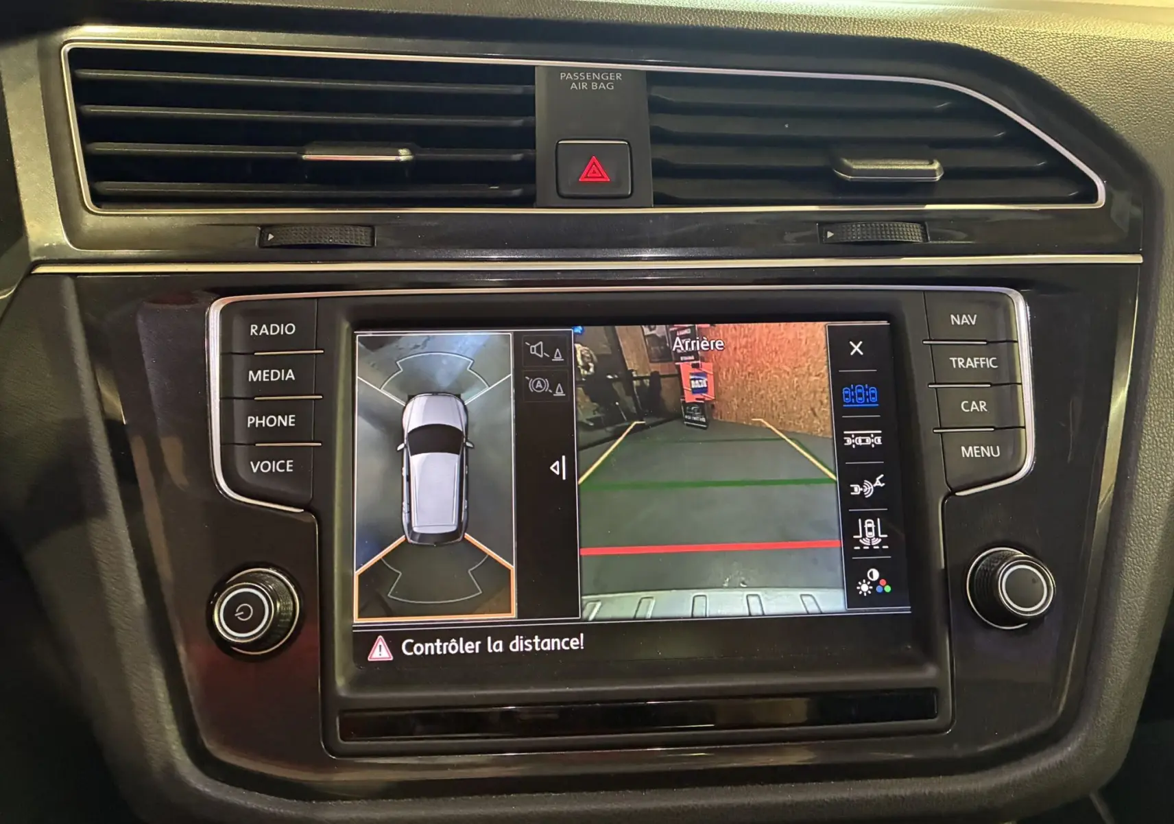 Vue rapprochée de l'écran central du Volkswagen Tiguan 2017 affichant la caméra de recul et l'aide au stationnement.